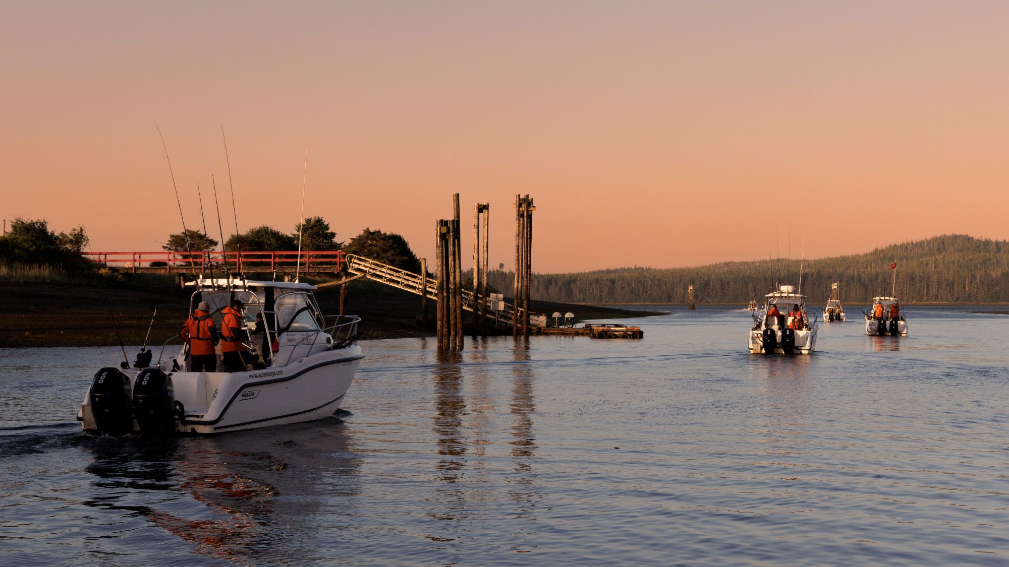 Photo Credit: Markus Thompson Sport fishing boats heading out on the water next to docks at sunrise