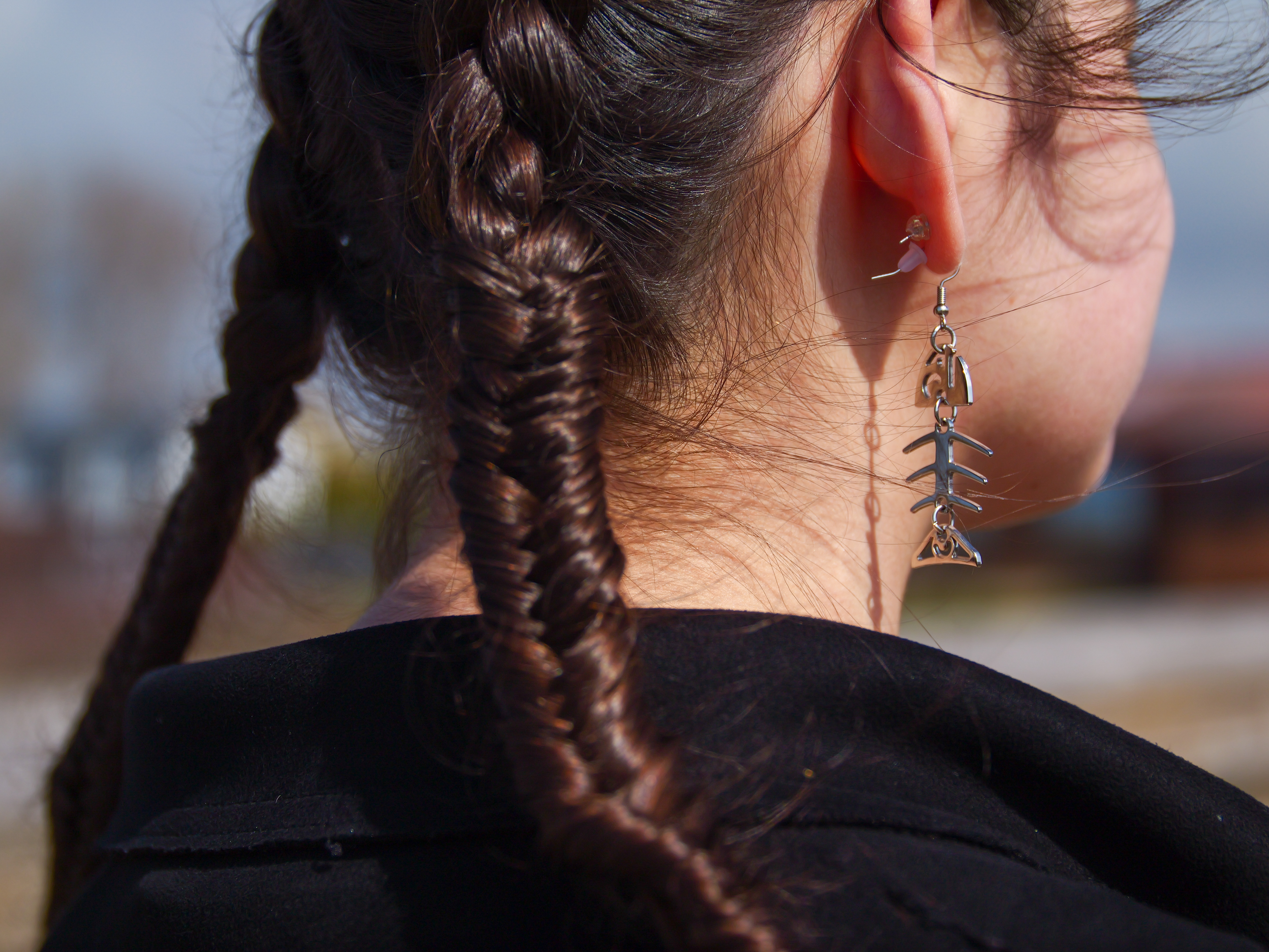 Close up of fishtail braid and fish skeleton earring