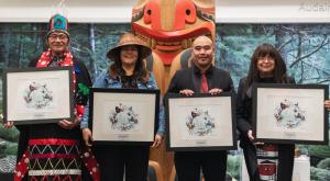 Four Indigenous leaders holding framed awards on stage